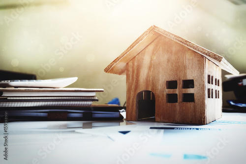 Photography House and property for sale concept, wood house toy on office desk