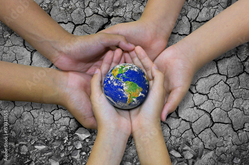 Earth planet in asian Children hand isolated on Ground arid barren © pkproject