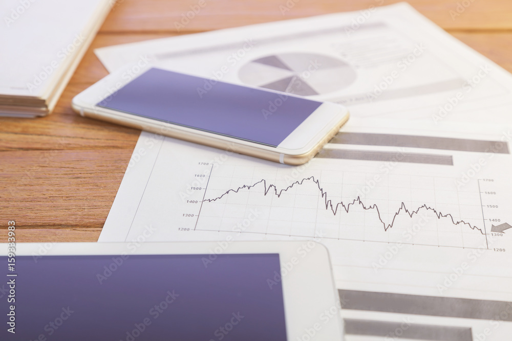Investment charts with laptop and calculator on wooden table workplace Investment charts with laptop and calculator on wooden table workplace