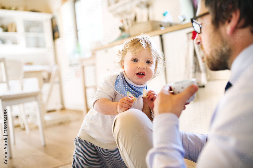 Businessman with his little son at home, drinking coffee. Businessman with his little son at home, drinking coffee.
