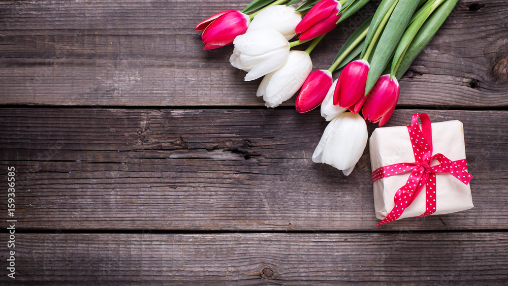 Box with gift and bright spring tulips flowers on rustic wooden background. S Box with gift and bright spring tulips flowers on rustic wooden background. S