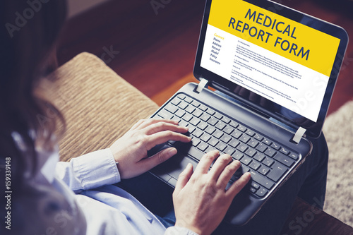 Woman fill in a medical report form with a laptop by internet.