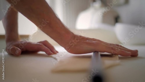 Baker hands rolling the dough photo