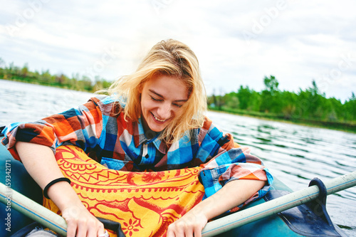 Young girl smiling on a walk on an inflatable boat on the river