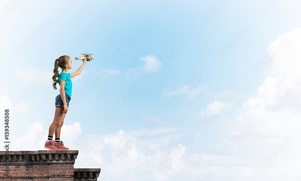 Concept of careless happy childhood with girl dreaming to become pilot Concept of careless happy childhood with girl dreaming to become pilot