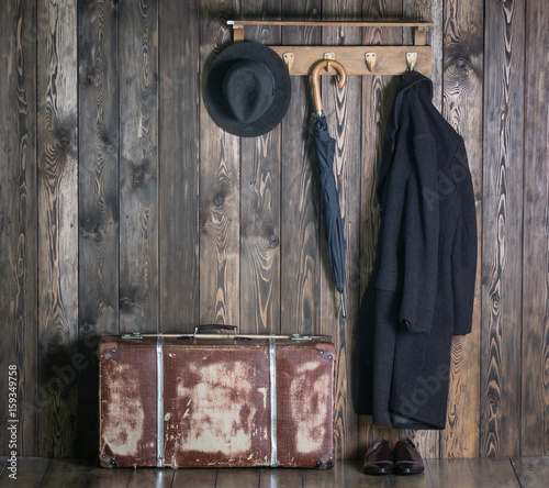Hanger with clothes, old suitcase