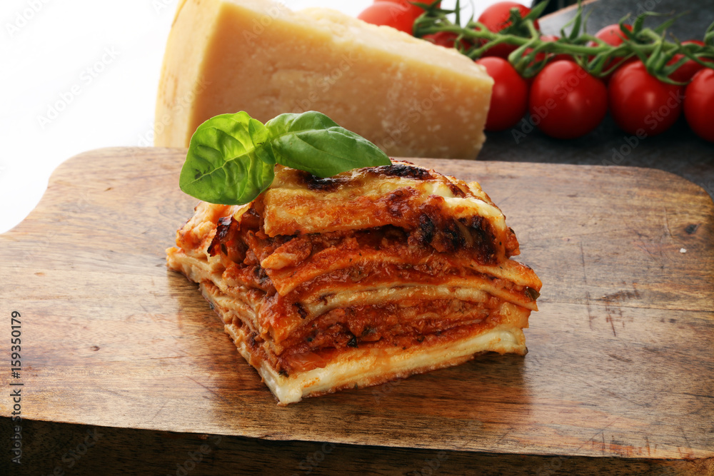 Serving of spicy traditional Italian beef lasagne in a restaurant - bolognese sauce topped with basil leafs Serving of spicy traditional Italian beef lasagne in a restaurant - bolognese sauce topped with basil leafs