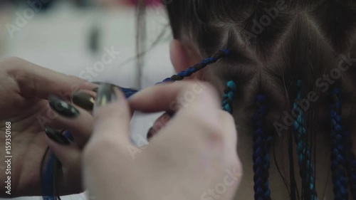 The process of weaving African braid with the use of kanekalon. Small African braids with blue artificial strands. Trend-braids: a modern and topical hairstyle - bright braids. photo