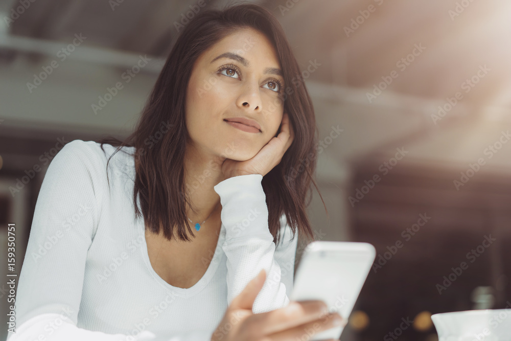 Romantic beautiful woman relaxing at cafe, Young woman in a cafe reading a text message from her mobile phone Romantic beautiful woman relaxing at cafe, Young woman in a cafe reading a text message from her mobile phone