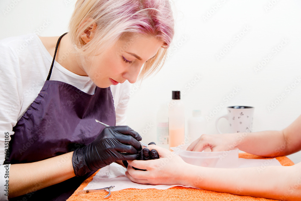 Manicure process concept. Close up view to beautician with cuticle remover. Manicure process concept. Close up view to beautician with cuticle remover.
