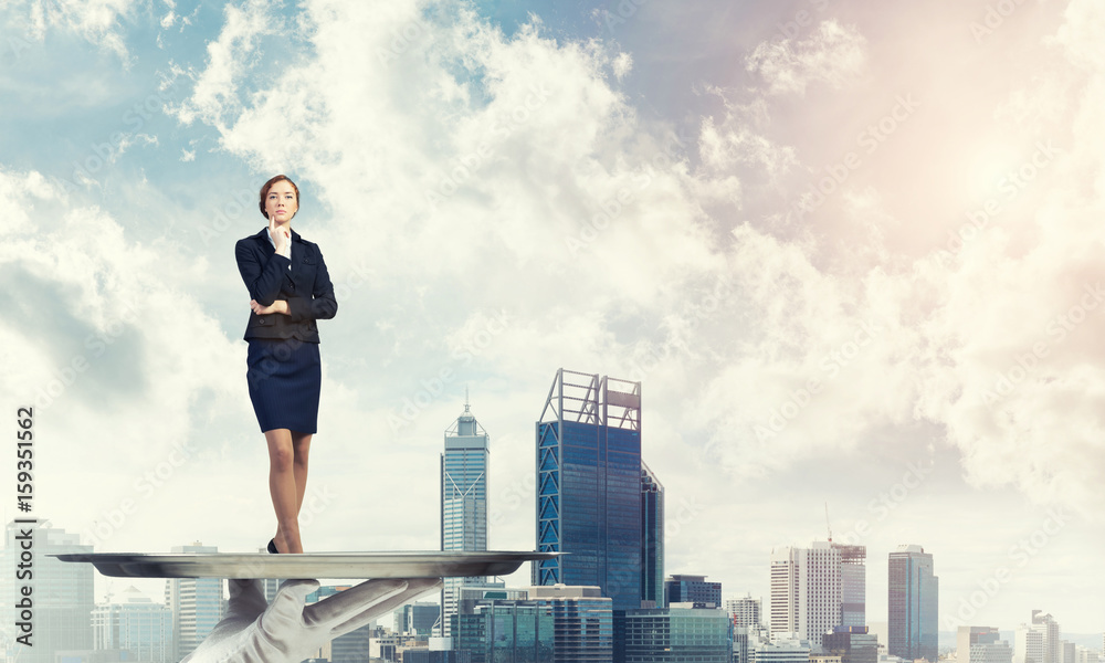 Confident elegant businesswoman presented on metal tray against cityscape background Confident elegant businesswoman presented on metal tray against cityscape background