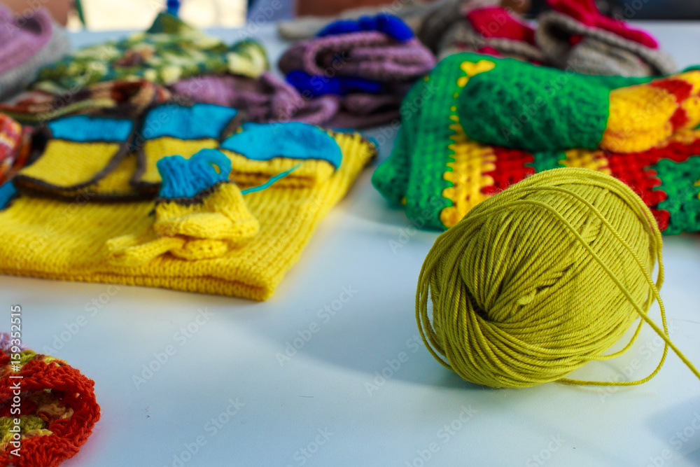 A tangle of woolen threads for knitting against the background of knitted clothes A tangle of woolen threads for knitting against the background of knitted clothes