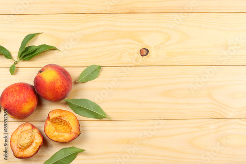Peach. Fruit with green leaf on light wooden background. top view with copy space