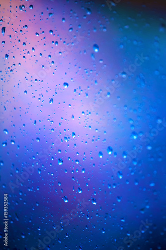 Drops of rain on a glass on a blue background