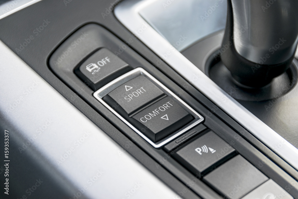 Track control buttons near automatic gear stick of a modern car, car interior details