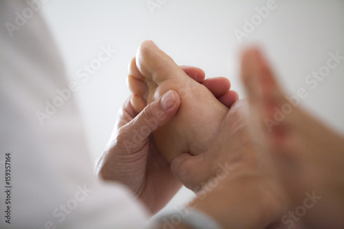 Close-up of reflexologist massaging woman's foot