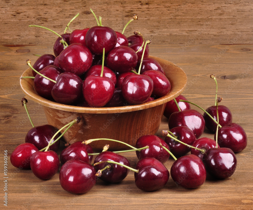 Cherries in a wooden bowl on a wooden background Cherries in a wooden bowl on a wooden background