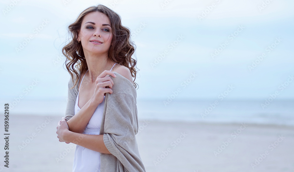 Woman face Portrait on the beach. Happy beautiful curly-haired girl close-up, the wind fluttering hair. Spring portrait on the beach. Young pretty girl. Young smiling outdoors portrait. Close. ocean. Woman face Portrait on the beach. Happy beautiful curly-haired girl close-up, the wind fluttering hair. Spring portrait on the beach. Young pretty girl. Young smiling outdoors portrait. Close. ocean.