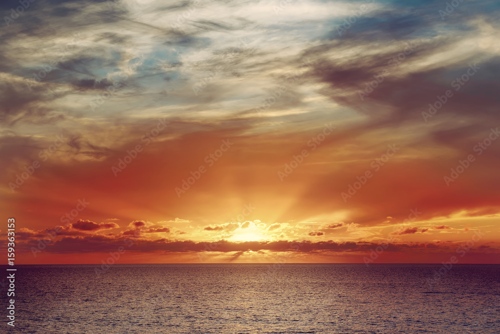 Beautiful colorful sunset at the sea with dramatic clouds and sun shining. Beauty world natural outdoors travel background Beautiful colorful sunset at the sea with dramatic clouds and sun shining. Beauty world natural outdoors travel background