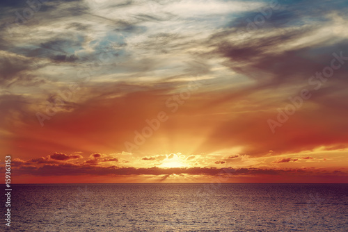 Beautiful colorful sunset at the sea with dramatic clouds and sun shining. Beauty world natural outdoors travel background