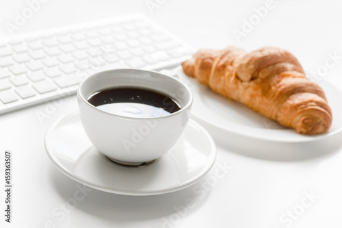 Business breakfast in office with coffee and croissant on white table background