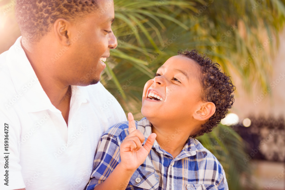 Mixed Race Son and African American Father Playing Outdoors Together. Mixed Race Son and African American Father Playing Outdoors Together.