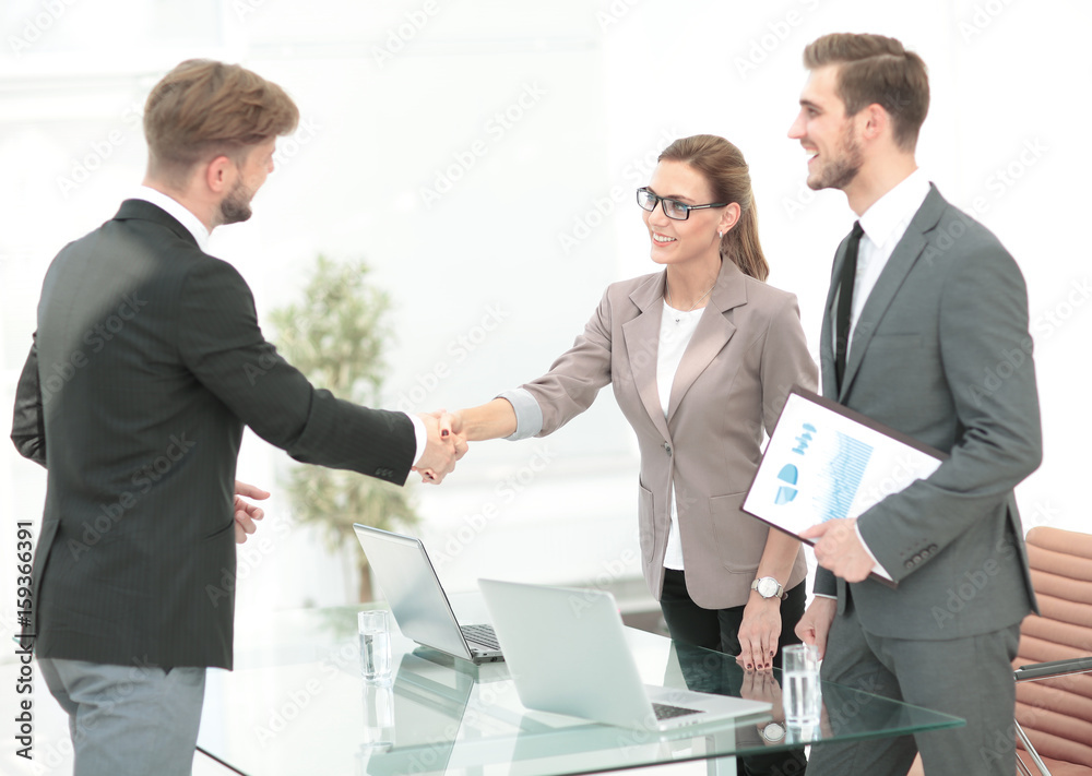 Business people closing a deal and handshaking at the office Business people closing a deal and handshaking at the office