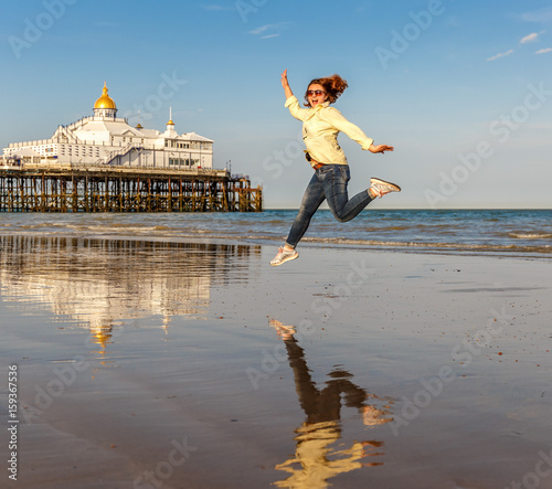 Slika na platnu Happy woman enjoying the sunset at Eastbourne, UK
