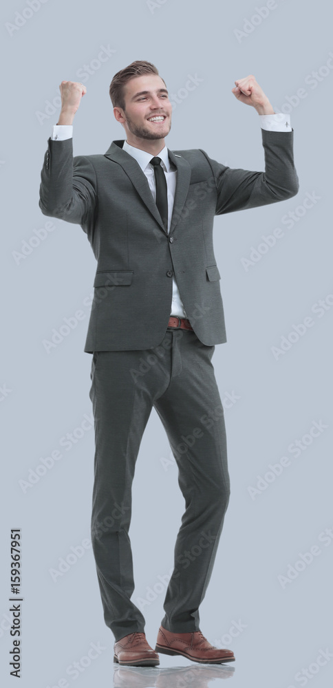 Excited smile business man raised arms, isolated over gray backg Excited smile business man raised arms, isolated over gray backg