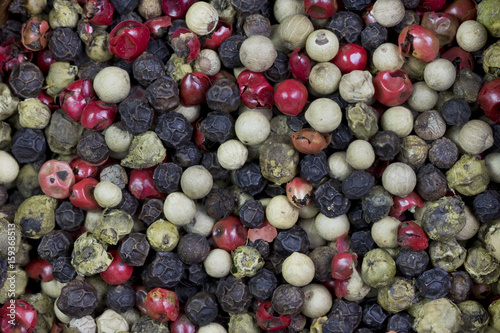 Background image of peppercorns of difference colors.