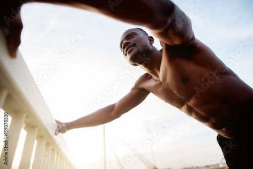 African american fitness handsome man training. Jogging against the morning sun.