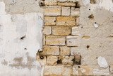 Grunge wall worn, rough masonry, cracks on the wall, plaster fell