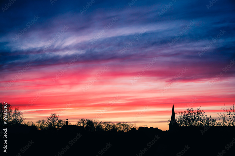 Sonnenuntergang in blau rot über Dorf mit Kirche