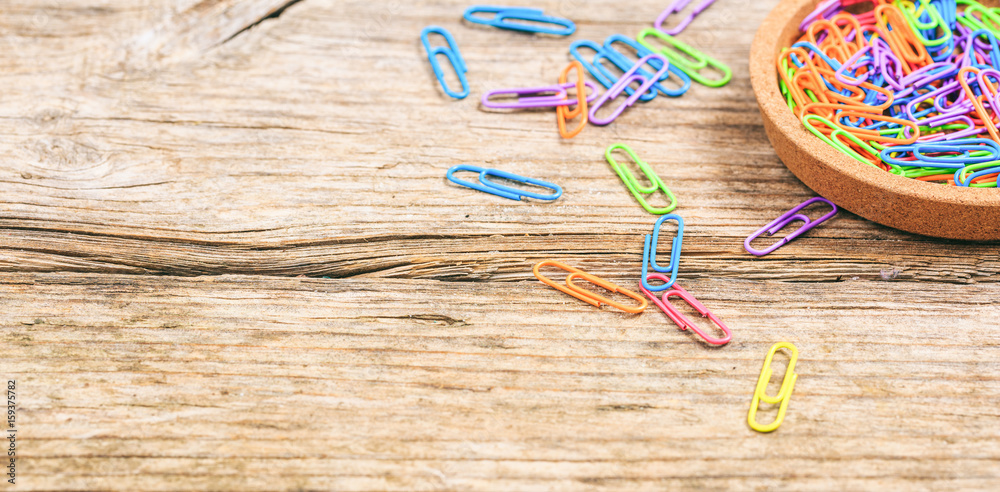 Paper clips on wooden background