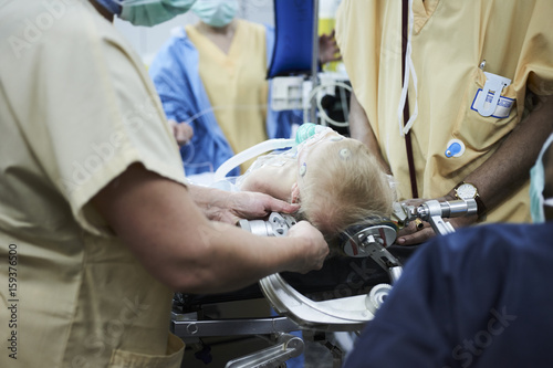 Doctors installing the cranial clamp to the patient's head