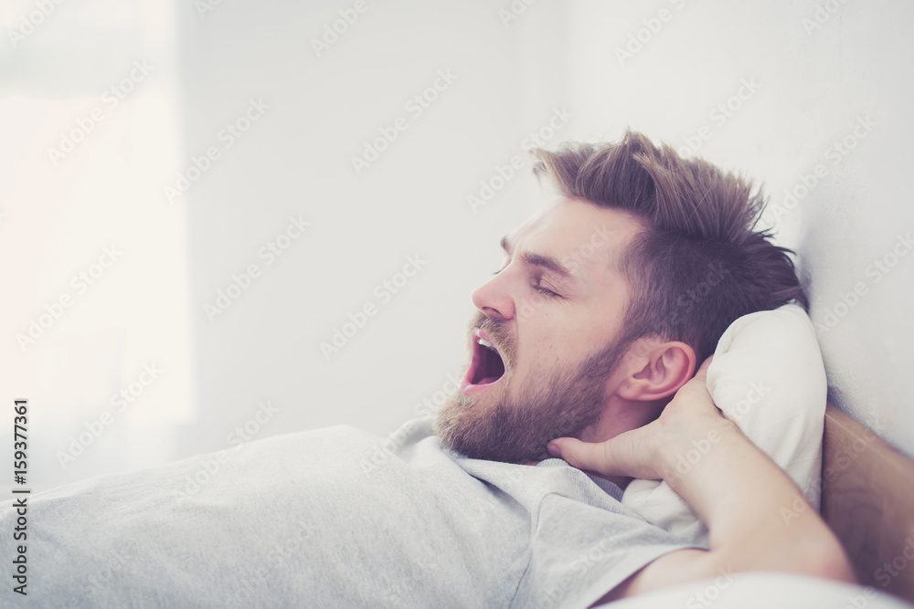 Handsome young american male yawn sleeping in bed at home - healthcare concept. Handsome young american male yawn sleeping in bed at home - healthcare concept.