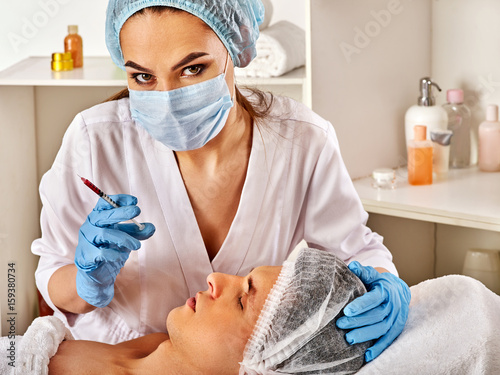 Filler injection for male forehead face. Plastic aesthetic facial surgery in beauty clinic. Man giving anti-aging injections. Doctor in medical gloves with syringe injects nasolabial fold drug photo