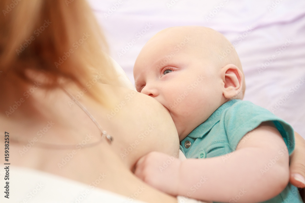 indoor portrait of mother breast feeding and hugging her baby at home indoor portrait of mother breast feeding and hugging her baby at home