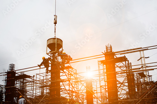 Silhouette construction industry team safely to work load concrete building according to set goal over blurred background sunset pastel for industry background.