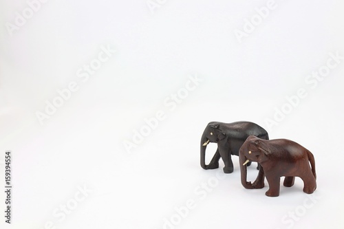 hand carved wooden elephants standing side by side isolated on white background 