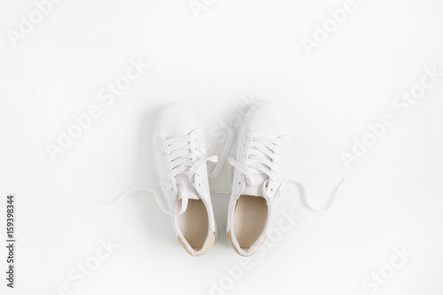 White female sneakers isolated on white background. Flat lay, top view
