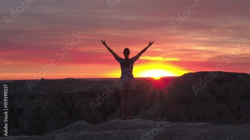 Wallpaper Mural SLOW MOTION CLOSE UP Young woman relaxing and raising her arms slowly towards the pink sky at stunning autumn sunset. Silhouette of a happy hiker rising hands up and enjoying the moment at red sunrise Torontodigital.ca