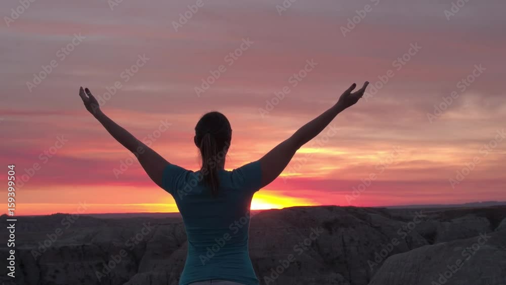 SLOW MOTION CLOSE UP: Young woman relaxing and raising her arms slowly towards the pink sky at stunning autumn sunset. Happy hiker peacefully rising hands up and enjoying the moment at red sunrise SLOW MOTION CLOSE UP: Young woman relaxing and raising her arms slowly towards the pink sky at stunning autumn sunset. Happy hiker peacefully rising hands up and enjoying the moment at red sunrise