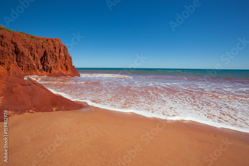 Waves at high tides breaking against the red pindan cliffs at James Price Point, Western Australia