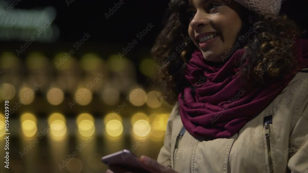 Happy biracial girl in good mood chatting in messenger with boyfriend, laughing