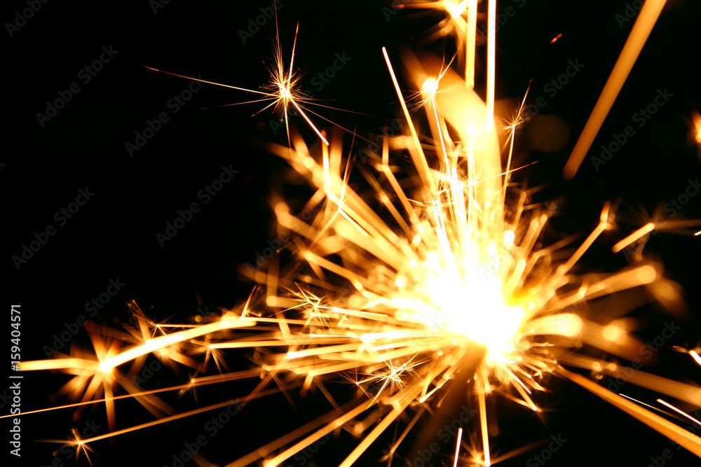 Sparklers background / A sparkler is a type of hand-held firework that burns slowly while emitting colored flames, sparks, and other effect