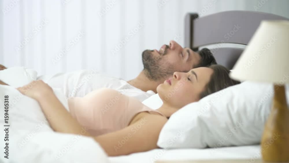 The man snore near the woman on the bed The man snore near the woman on the bed