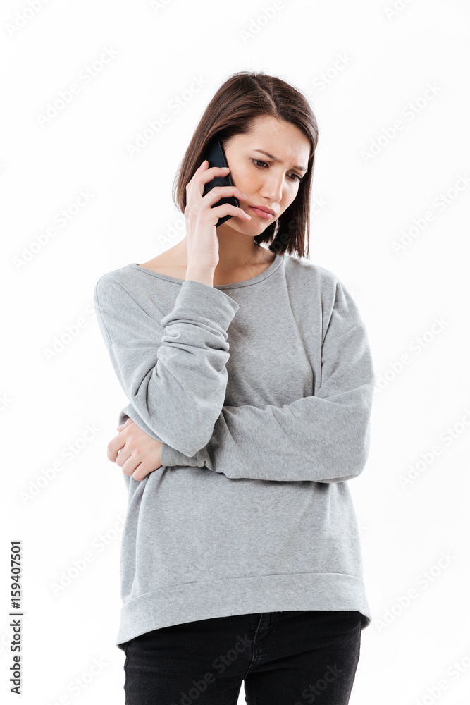 Sad young caucasian woman talking by phone. Sad young caucasian woman talking by phone.
