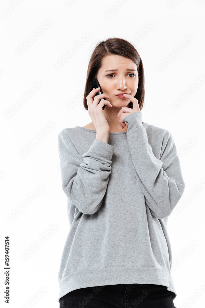 Sad young caucasian woman talking by phone. Sad young caucasian woman talking by phone.