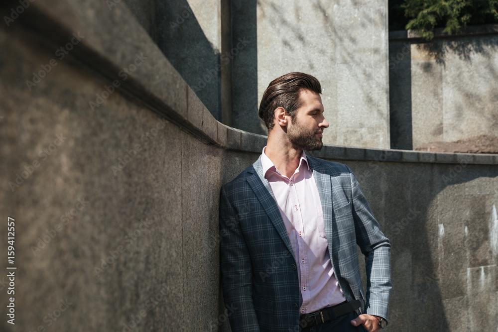 Fototapeta premium Handsome young businessman walking outdoors